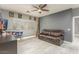 Stylish living room with a sofa, pinball, and a large wall-mounted TV at 44566 W High Desert Trl, Maricopa, AZ 85139
