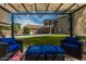 Outdoor seating area with canopy overlooking green lawn and swimming pool at 44566 W High Desert Trl, Maricopa, AZ 85139
