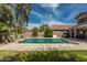 Backyard pool with lush landscaping and travertine tile is ideal for entertaining at 44566 W High Desert Trl, Maricopa, AZ 85139