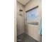 Modern shower with gray tiles, a showerhead, and a window at 44566 W High Desert Trl, Maricopa, AZ 85139