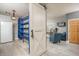 Bright storage room with modern barn door, shelving, and comfortable arm chairs at 44566 W High Desert Trl, Maricopa, AZ 85139