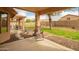 Relaxing covered back patio with stone pavers, an outdoor chair, and a view of the backyard at 4909 W Pedro Ln, Laveen, AZ 85339