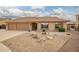 Inviting single-story home showcasing a well-maintained yard with decorative rock and a spacious three-car garage at 4909 W Pedro Ln, Laveen, AZ 85339