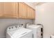 Laundry room with top-loading washer and dryer, featuring ample cabinet space for storage at 4909 W Pedro Ln, Laveen, AZ 85339