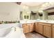 This primary bath includes double sinks, a soaking tub, and tiled floors at 4909 W Pedro Ln, Laveen, AZ 85339
