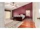The primary bedroom features wood floors, a ceiling fan, and a decorative rug at 4909 W Pedro Ln, Laveen, AZ 85339