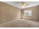 Bright bedroom featuring a ceiling fan, neutral carpet, and a window with outside views at 5410 E Gable Ave, Mesa, AZ 85206