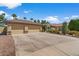 This attractive house features a three-car garage, desert landscaping, and easy-to-maintain greenery at 5410 E Gable Ave, Mesa, AZ 85206