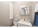 Cozy bathroom with a sink, mirror, toilet, and stylish blue and white striped towels at 690 S 92Nd Pl, Mesa, AZ 85208