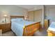 Cozy bedroom with wooden bed frame, side tables with lamps, and closet with sliding doors at 6913 W Wilshire Dr, Phoenix, AZ 85035