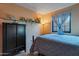 Bedroom with a bed, dark wardrobe, and shelf with decorative items at 6913 W Wilshire Dr, Phoenix, AZ 85035