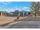 Charming single-story home with desert landscaping, covered carport, and inviting blue chairs on the front porch at 6913 W Wilshire Dr, Phoenix, AZ 85035