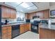 Functional kitchen with ample counter space, wood cabinets, and black appliances, perfect for cooking and meal prep at 6913 W Wilshire Dr, Phoenix, AZ 85035
