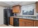 Efficient kitchen featuring black appliances, plenty of storage, and granite counters at 6913 W Wilshire Dr, Phoenix, AZ 85035