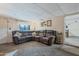 Cozy living room featuring a large brown sectional sofa and neutral carpeting throughout at 6913 W Wilshire Dr, Phoenix, AZ 85035