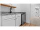 Convenient wet bar area with granite countertop, white cabinetry, and a mini refrigerator at 7664 W Minton St, Laveen, AZ 85339