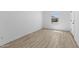 Bright, minimalist bedroom featuring durable wood-look flooring and a large window for natural light at 7664 W Minton St, Laveen, AZ 85339