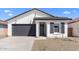 Charming single-story home with a gray garage door, minimalist desert landscaping, and a crisp white exterior at 7664 W Minton St, Laveen, AZ 85339