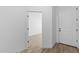 Bright foyer with wood-look tile floors and white walls, leading to a bright living space and a white interior door at 7664 W Minton St, Laveen, AZ 85339