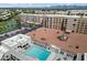 Aerial view showcasing the building's pool, surrounding sunbathing area and nearby apartment buildings at 7840 E Camelback Rd # 111, Scottsdale, AZ 85251