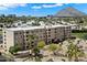 An exterior view of the apartments showcasing beautiful landscaping with a mountain view at 7840 E Camelback Rd # 111, Scottsdale, AZ 85251