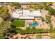 Aerial of a home with a well-manicured lawn, pool, desert landscaping, and mountain views at 7921 N 54Th St, Paradise Valley, AZ 85253