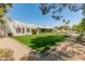 Expansive backyard with lush green lawn and desert landscaping, creating a private retreat with mature trees and foliage at 7921 N 54Th St, Paradise Valley, AZ 85253