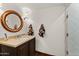 Bathroom featuring a round mirror and custom vanity with stone countertop at 7921 N 54Th St, Paradise Valley, AZ 85253