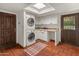Laundry Room featuring stacked washer and dryer, ample countertop space, and storage cabinets at 7921 N 54Th St, Paradise Valley, AZ 85253