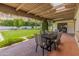 Covered outdoor dining area with seating for six, offering a great view of the lush backyard and surrounding landscape at 7921 N 54Th St, Paradise Valley, AZ 85253