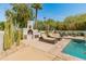 Resort-style pool area with lounge chairs, stucco fireplace and desert landscaping at 7921 N 54Th St, Paradise Valley, AZ 85253