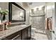Modern bathroom with a granite countertop vanity and a glass-enclosed tiled shower at 8220 E Mohawk Ln, Scottsdale, AZ 85255