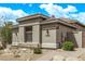 Lovely single-story home showcasing a neutral stucco exterior, stone accents, and beautiful desert landscaping at 8220 E Mohawk Ln, Scottsdale, AZ 85255