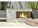 Outdoor fireplace with a stacked stone design surrounded by desert landscaping, enhancing the backyard's ambiance at 8220 E Mohawk Ln, Scottsdale, AZ 85255