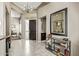 Inviting foyer with a modern chandelier, stylish mirror, and a dark wood front door at 8220 E Mohawk Ln, Scottsdale, AZ 85255