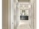 Hallway with louvered doors, leading to bathroom with modern lighting fixture at 8220 E Mohawk Ln, Scottsdale, AZ 85255