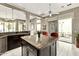 Kitchen island with granite countertops, dark cabinetry, and backyard patio access at 8220 E Mohawk Ln, Scottsdale, AZ 85255