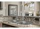 Stainless steel kitchen sink and faucet with a decorative mosaic backsplash at 8220 E Mohawk Ln, Scottsdale, AZ 85255