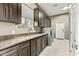 Spacious laundry room with dark cabinets, granite countertops, and modern washer and dryer units at 8220 E Mohawk Ln, Scottsdale, AZ 85255