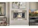 Modern fireplace design with stainless steel and a cozy seating area and television at 8220 E Mohawk Ln, Scottsdale, AZ 85255