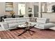 Comfortable sectional sofa with a stylish glass coffee table in a naturally lit living area at 8220 E Mohawk Ln, Scottsdale, AZ 85255