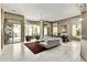 Spacious living room with large windows, a modern sofa, and access to the outdoor patio at 8220 E Mohawk Ln, Scottsdale, AZ 85255