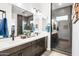 Modern bathroom featuring double sinks, stylish cabinets, a large mirror, and a glass-enclosed shower with gray tile at 830 E Buist Ave, Phoenix, AZ 85042
