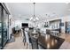 Open-concept dining area featuring a long table, chandelier, and views into the living room and kitchen at 830 E Buist Ave, Phoenix, AZ 85042