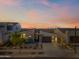 A modern home features a three-car garage and a desert landscaped front yard at sunset at 830 E Buist Ave, Phoenix, AZ 85042