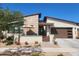 Modern home featuring a two-car garage, low-maintenance landscaping, and charming front patio at 830 E Buist Ave, Phoenix, AZ 85042