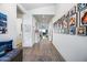 Inviting hallway with an area rug, tile floors, and walls adorned with framed photos at 830 E Buist Ave, Phoenix, AZ 85042