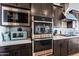 Elegant kitchen featuring stainless steel appliances, dark cabinets, and a sleek design for modern cooking at 830 E Buist Ave, Phoenix, AZ 85042