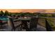 Elegant patio with a cozy fire pit table, comfortable seating, and a view of the pool under a vibrant sunset sky at 830 E Buist Ave, Phoenix, AZ 85042