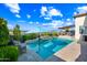 Stunning backyard pool with stone accents, umbrella, and patio furniture, perfect for outdoor relaxation and entertaining at 830 E Buist Ave, Phoenix, AZ 85042